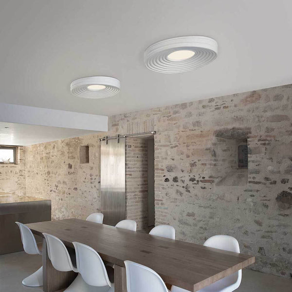 Karman LED-Deckenleuchte R.O.M.A. in modernem Raum, mit eleganten Wellenmustern und direkter Beleuchtung.