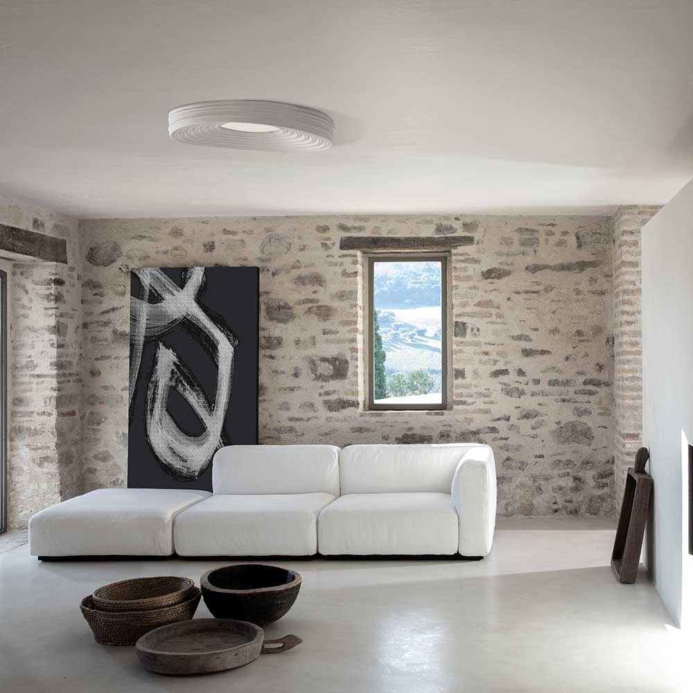 Moderne Karman LED-Deckenleuchte R.O.M.A. in stilvollem Wohnraum mit hellen Wänden und minimalistischer Dekoration.