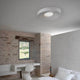 Karman LED-Deckenleuchte R.O.M.A. in modernem Schlafzimmer mit strukturierter Wand.