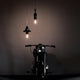 Karman Mek 1 Hängelampe Ø 8cm in moderner Umgebung mit Motorrad und stilvollem Licht.