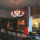 Karman Snoob Kronleuchter in modernem Restaurant, elegantes Design in Schwarz und Weiß, atmosphärische Beleuchtung.