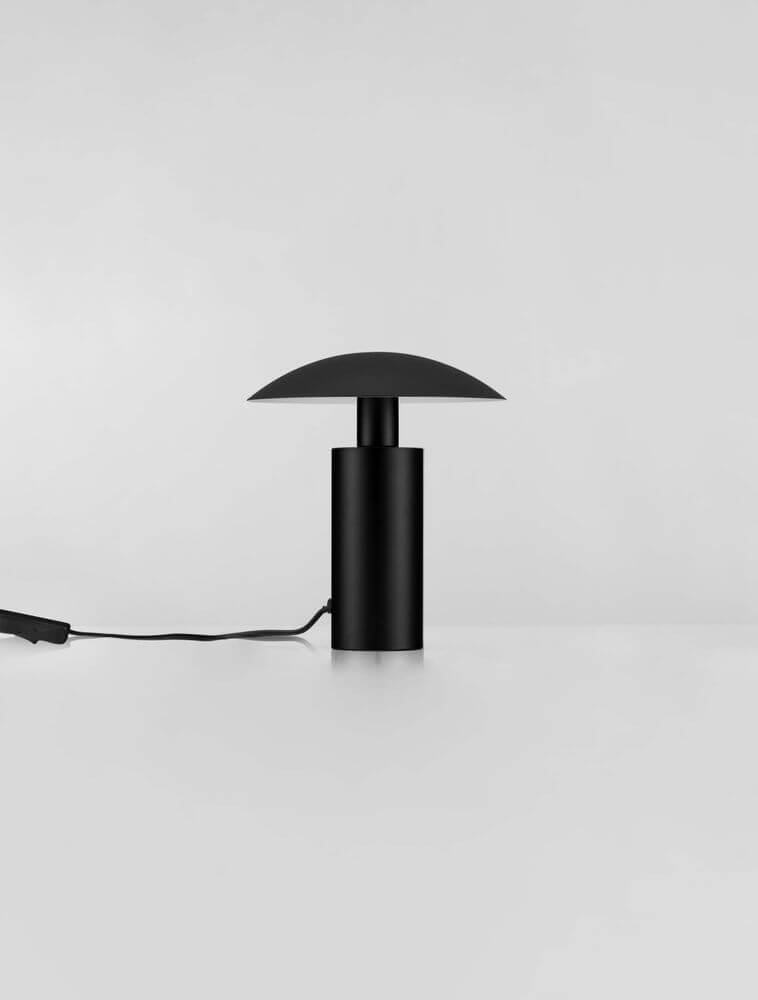 Karpos LED Tischleuchte Ø 20cm 3000K in modernem schwarzen Design auf einem Tisch.