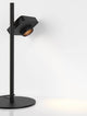 Kedros LED Tischleuchte 3000K mit Lampenfuß auf einem Tisch, moderner Stil, schwarze Stahl- und Aluminiumkonstruktion.