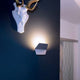 Keo indirekte LED-Wandleuchte Dim2warm an einer blauen Wand, erzeugt sanftes Licht und setzt stilvolle Akzente.