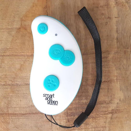 Télécommande Key Mesh Accessoire pour lampes à batterie-LED sur fond couleur bois.