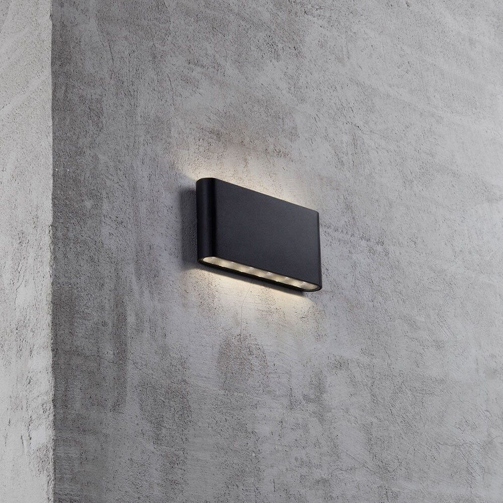 Kinver LED Außen-Wandleuchte IP54 Schwarz an einer Wand installiert, bietet elegantes Lichtdesign für den Außenbereich.