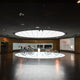 K-Aera Flat LED Einlegeleuchte HCL RGB CCT DALI in einem modernen Ausstellungsraum mit historischen Fahrrädern.