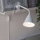 Klemmlampe Vitis mit Flexarm Schnurschalter Weiß an einem Regal befestigt, bietet vielseitige Beleuchtung.