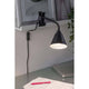 Klemmleuchte Vitis mit Flexarm Schnurschalter Schwarz an einem Tisch montiert, ideal für flexibles, sicheres Licht.