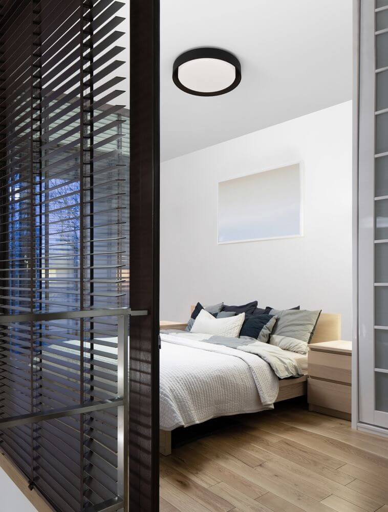 Koi LED Deckenleuchte Ø 48cm 3000K in modernem Schlafzimmer mit hellem Holzfußboden