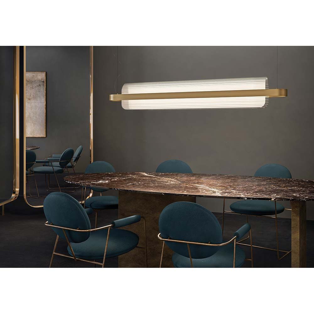 Kundalini LED Esstischleuchte Nami über einem eleganten Tisch mit blauen Stühlen in modernem Interieur.