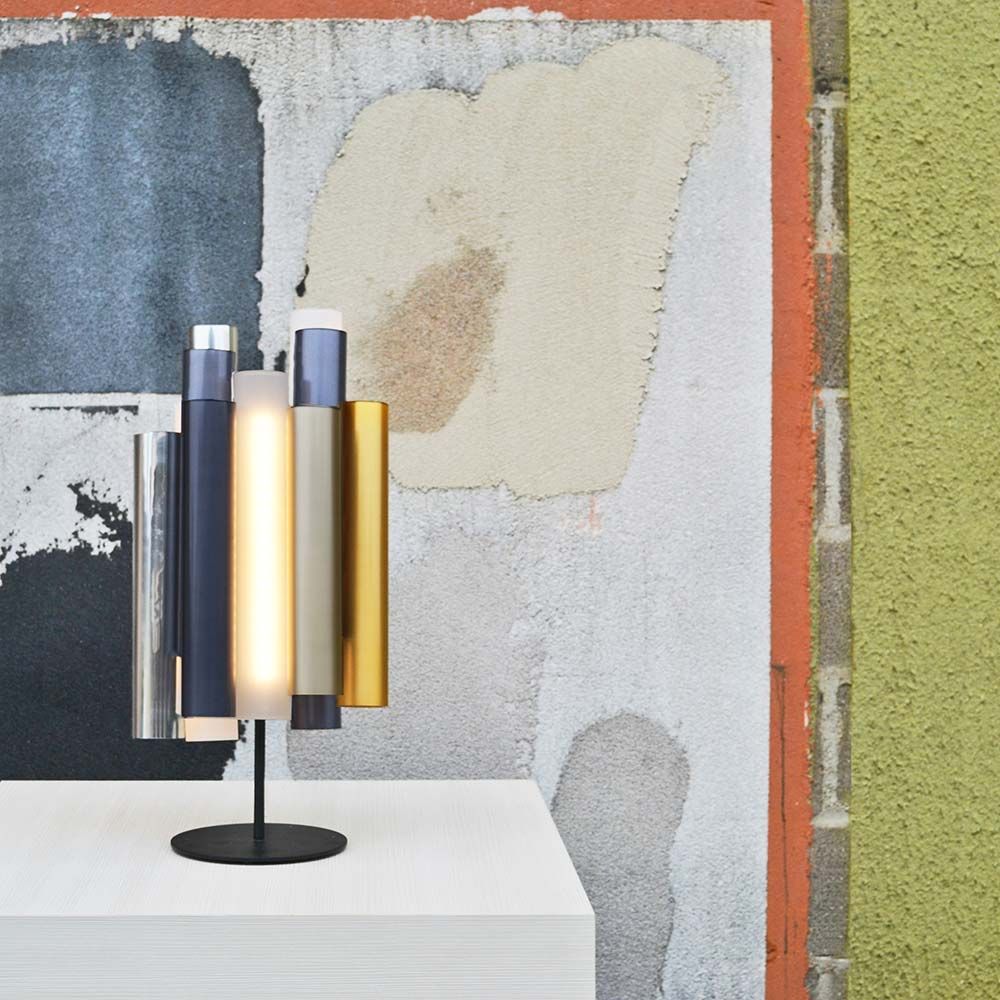 Kundalini LED Tischlampe Toot 62cm mit Dimmer, moderne mehrfarbige Lampe auf Tisch vor einer Wand.