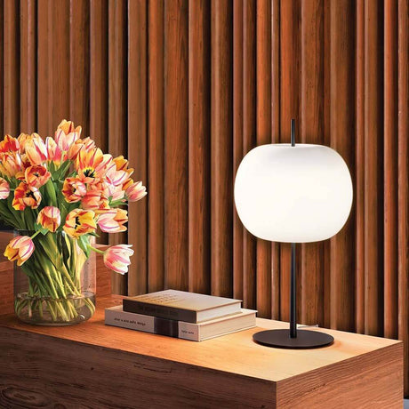 Kundalini Opalglas Tischleuchte Kushi XL 61cm mit Dimmer auf einem Tisch neben einem Blumenstrauß und Büchern.