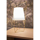 Kundalini Tischlampe Tatu 69cm mit Dimmer auf einem Tisch, mit geometrischem Design und goldener Struktur.