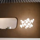 Kundalini Wand- & Deckenlampe Pixel Dimmbar an einer Wand mit kreativem Design und sanftem Licht.