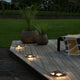 LED 4-Wege Boden Einbaustrahler IP65 auf deck, beleuchtet mit Pflanzen im Hintergrund, modernes Design.