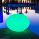 LED Akkulampe Flatball L mit App-Steuerung in grünem Licht am Pool.