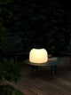 LED Akkuleuchte Kettle To-Go 36 IP65 auf einem Tisch im Freien, ideal für stimmungsvolle Beleuchtung.