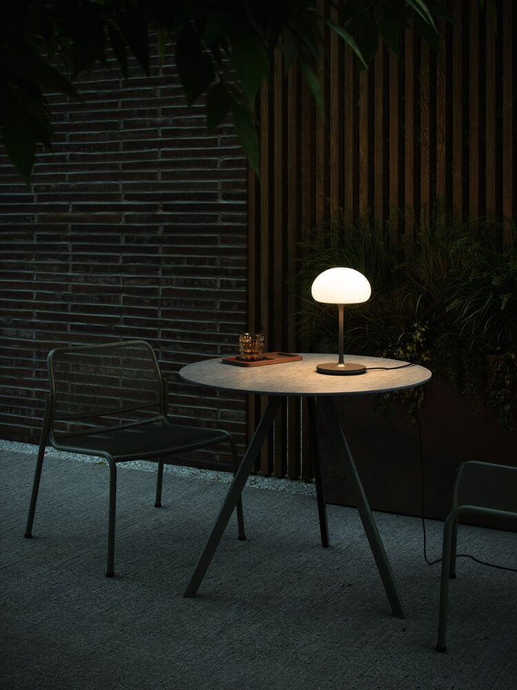 LED Akkuleuchte Sponge On A Stick IP44 auf einem Tisch im Außenbereich bei gedämpftem Licht.