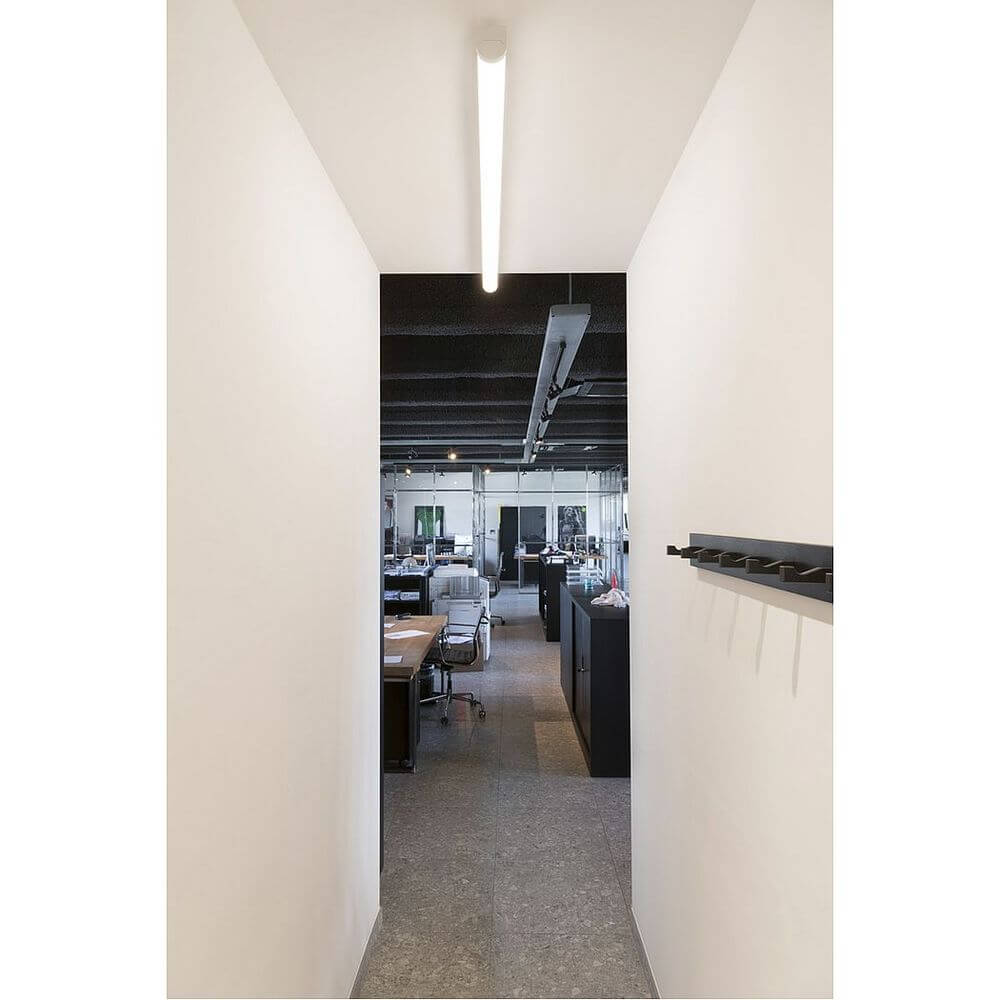 LED Aufbauleuchte Bena 150 4400lm 3000K Weiß in modernem Büroflur, funktionale Beleuchtung für professionelle Einrichtungen.