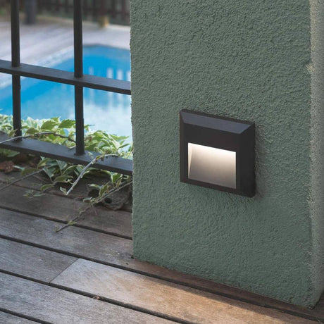 LED Surface-mounted light GRANT-R 3000K IP65 dark grey seawater-resistant on a wall next to a pool.