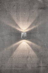 Minimalistische LED Außen-Wandleuchte Canto Kubi 2 mit einzigartigem Lichterlebnis an Betonwand.