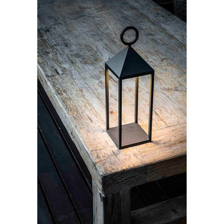 LED Battery-powered outdoor lantern light ARGUS IP54 dark grey on a wooden table.
