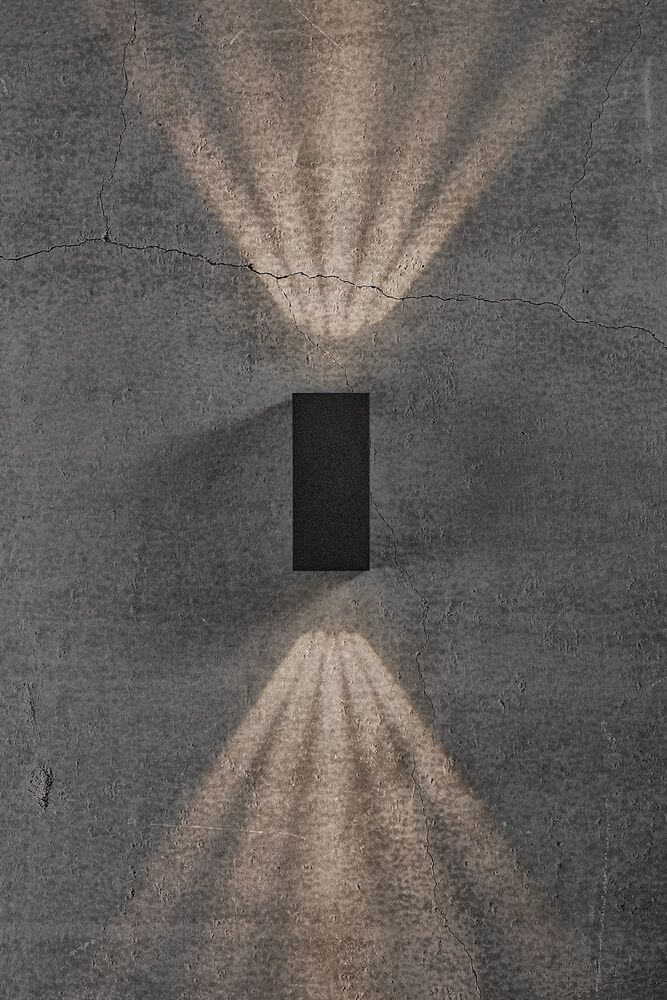 LED Außenwandlampe Asbol Kubi IP44 an einer Wand mit Lichtstrahlen nach oben und unten.