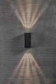 LED Außenwandlampe Asbol Kubi IP44 an einer Wand mit Lichtstrahlen nach oben und unten.