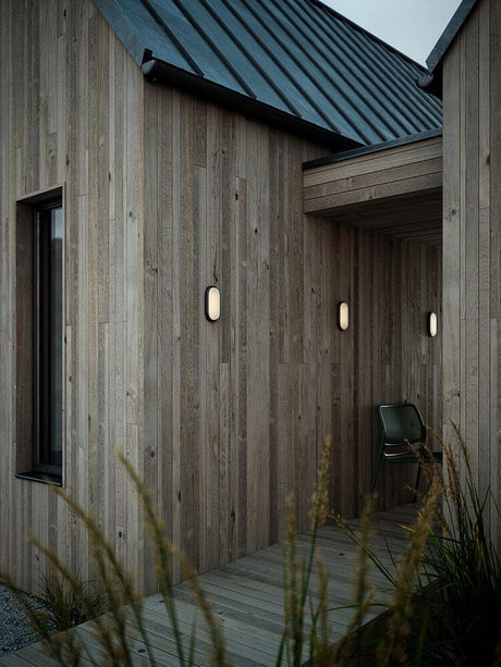 LED Outdoor wall light Cuba Outdoor Energy Oval IP54 on the wooden facade of a modern house.