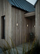 LED Außenwandlampe Cuba Outdoor Energy Oval IP54 an der Holzfassade eines modernen Hauses.