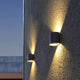 LED Außenwandlampe Dodd IP54 Anthrazit an einer Wand mit warmweißen Lichtkegeln.