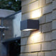 LED Außenwandlampe Gemini IP54 Anthrazit an einer Mauer montiert, das Up-&-Down-Licht erzeugt Lichteffekte.