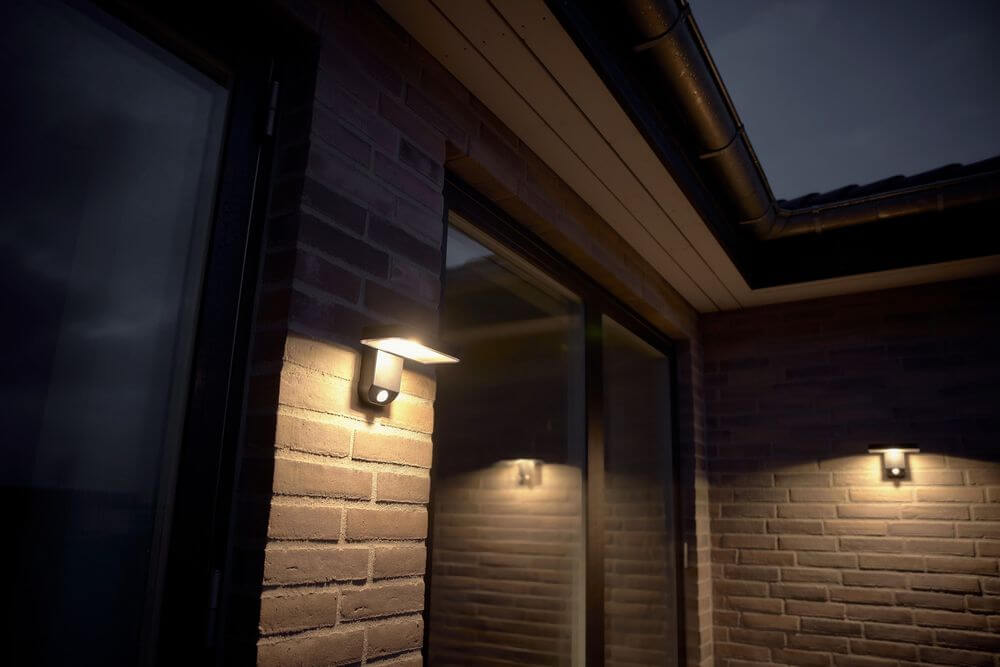 LED Außenwandlampe Rica Square Solar IP44 an einem modernen Gebäude bei Nacht.