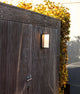 LED Außenwandleuchte Adalyn IP44 Anthrazit an einer Wand mit herbstlichem Laub im Hintergrund.