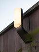 LED Außenwandleuchte Bati IP44 Anthrazit an einer Holzwand montiert, strahlt helles Licht aus.