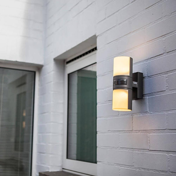 LED Außenwandleuchte Cyra mit Sensor IP44 Anthrazit an einer weißen Wand installiert.
