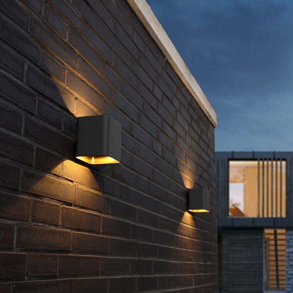 LED Außenwandleuchte Dodd IP54 Anthrazit an einer Wand, warmweißes Licht erzeugt dekorative Effekte.