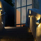 LED Außenwandleuchte Dodd IP54 Edelstahl an einer Treppe mit warmweißen Lichtkegeln.