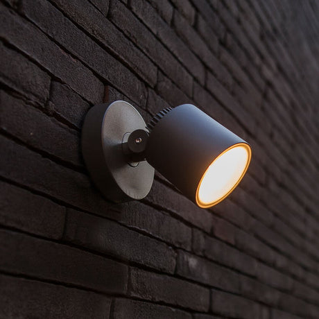 LED-Außenwandleuchte Explorer schwenk- & drehbar an einer Backsteinwand montiert, strahlend warmes Licht.