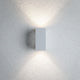 LED Außen Wandleuchte Flame Metall Weiß an einer Wand mit warmem Lichtschein.