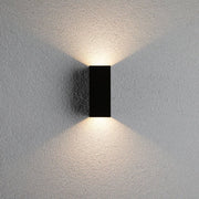 LED Außenwandleuchte Flame Eckig 65x70mm Anthrazit mit indirekten Lichtakzenten an der Wand.