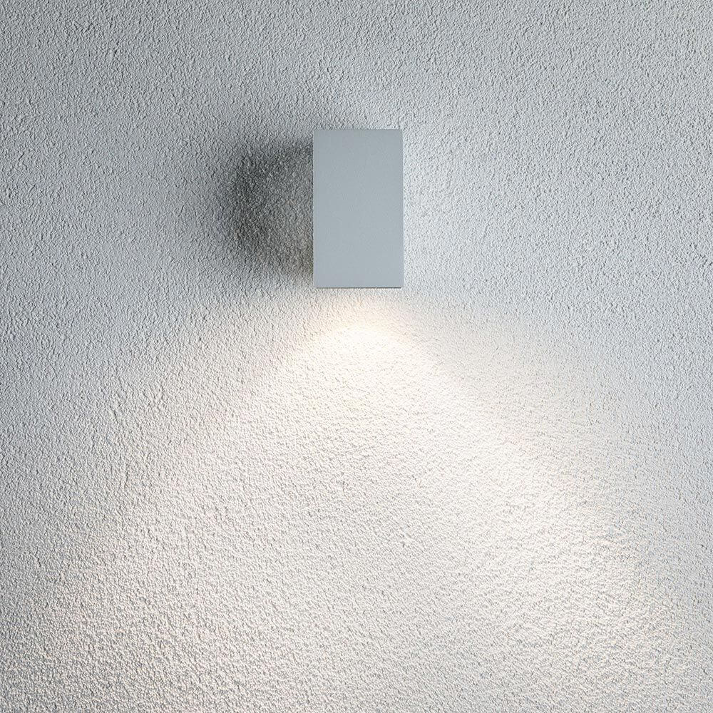 LED Außenwandleuchte Flame Weiß, Metall an einer Wand, beleuchtet den Bereich mit indirektem Licht.