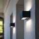 LED-Außenwandleuchte Gemini Anthrazit 22cm an einer Wand, stilvolles Design mit warmem Licht.