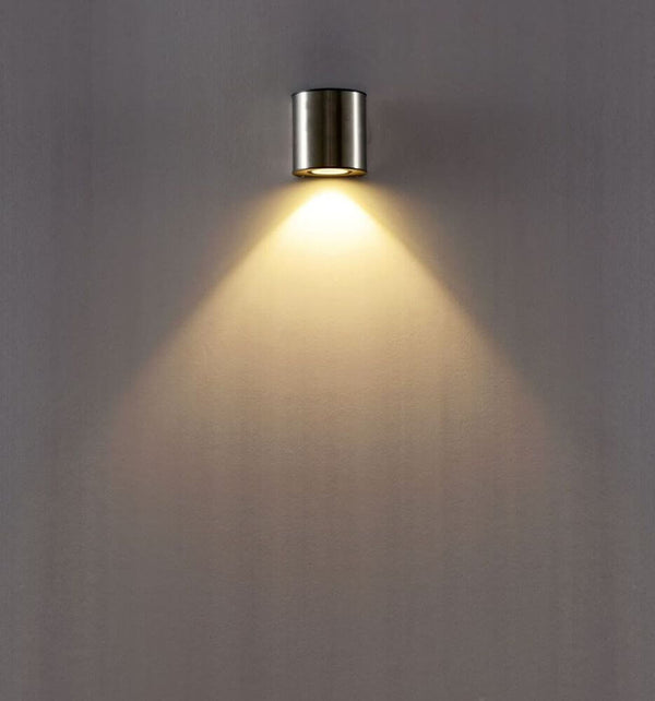 LED Außenwandleuchte Ilumi IP54 Chrom an einer Wand mit warmem Licht.