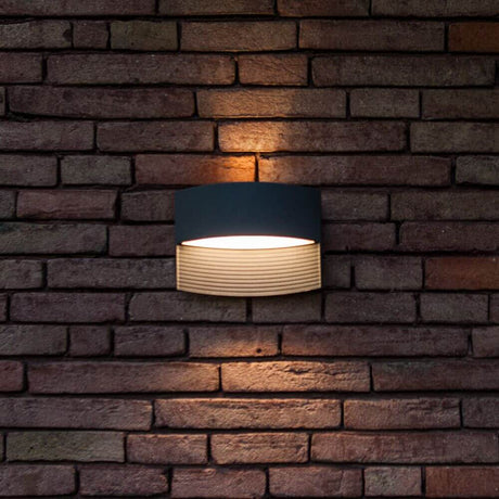 LED Außenwandleuchte Lotus IP54 Anthrazit an Ziegelwand mit warmweißem Licht