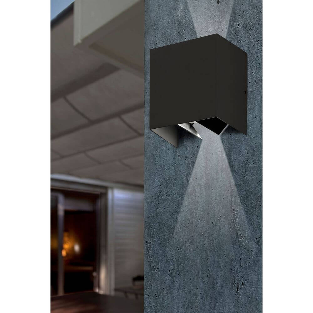 LED Außenwandleuchte OLAN 3000K IP54 Dunkelgrau an einer Wand mit Lichtschein in einem modernen Außenbereich.
