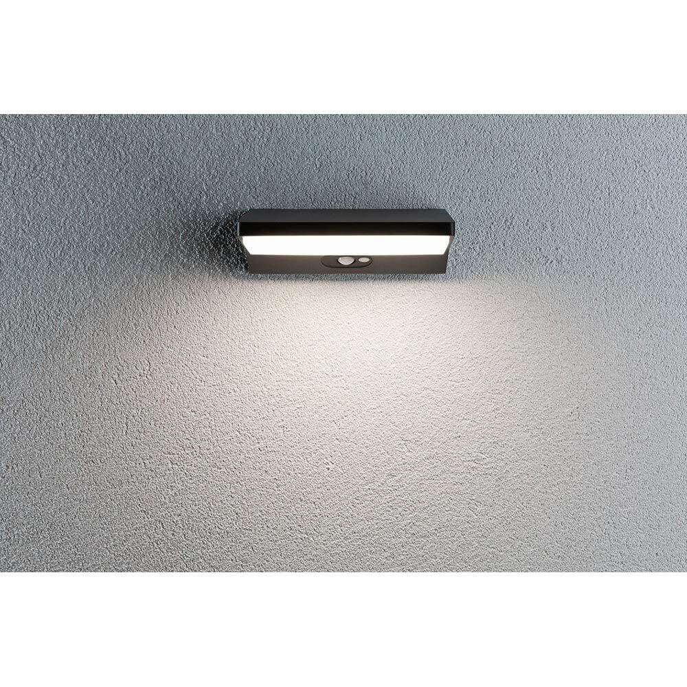 LED Außenwandleuchte Ronea Bewegungsmelder Alu, Dunkelgrau IP44 an einer Wand montiert, strahlendes Licht.
