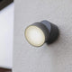 LED Außenwandleuchte Trumpet M IP54 Anthrazit an einer Wand montiert, strahlendes Licht.
