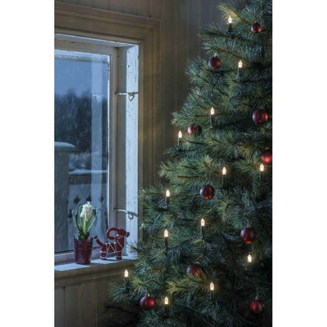 LED Baumkette Topbirnen grün One String 16 warmweiße Dioden geschmackvoll dekorierter Weihnachtsbaum mit Fensteraussicht.